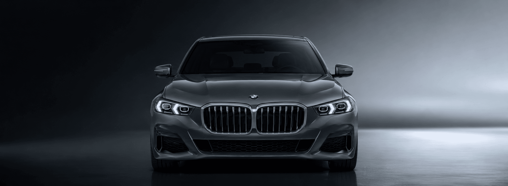 سيارة BMW داكنة من الأمام داخل استوديو بإضاءة سينمائية